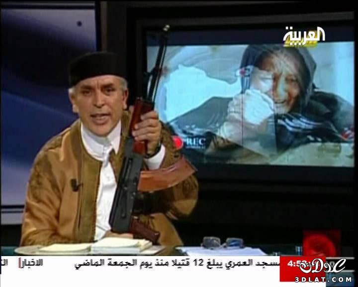 مذيع ليبي يحمل رشاشاً أثناء تقديم برنامجه على الهواء
